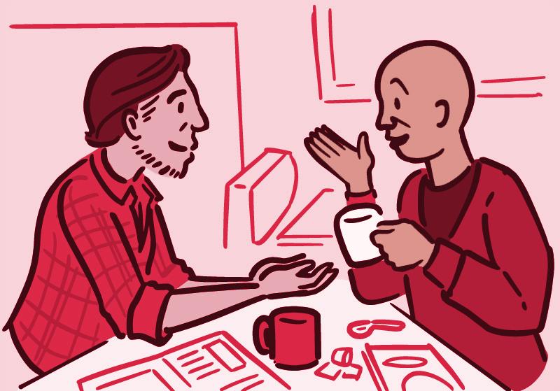 Two men at a table engaged in conversation over a cup of coffee