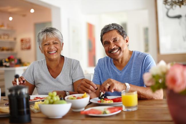 A happy older couple enjoying a healthy breakfast together at home.