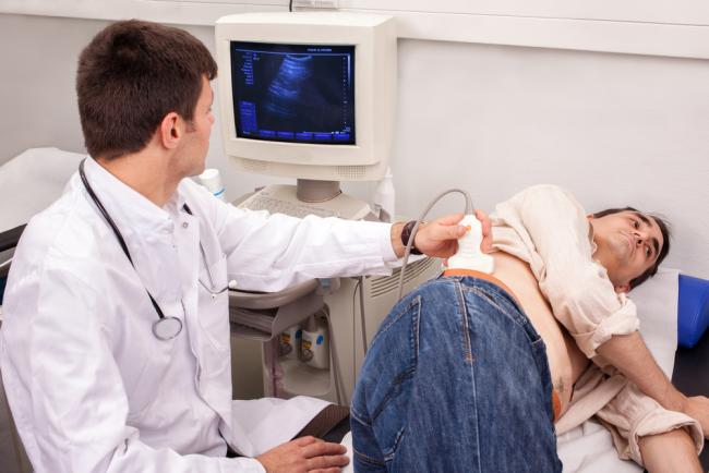 Doctor looking for kidney stones with an ultrasound scanner.