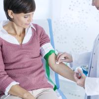 Doctor preparing a woman’s arm for a blood test.