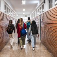 High school students walking down school hallway after class 