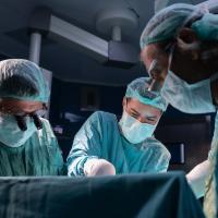 Open heart surgery, doctors and cardiologists perform open heart surgery. Doctors in green uniforms in the operating room. 