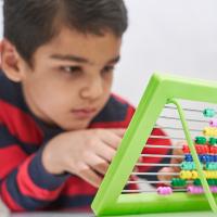 Boy focused on working with an abacus.